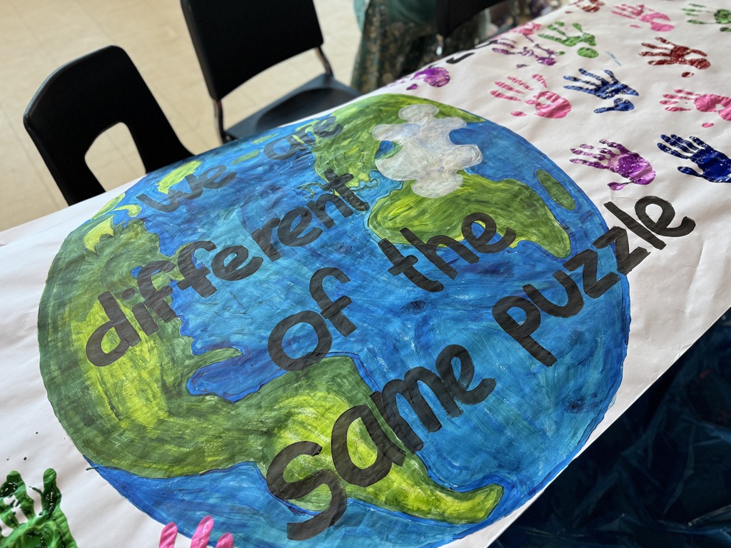 A canvas painted to say "We are different pieces of the same puzzle."