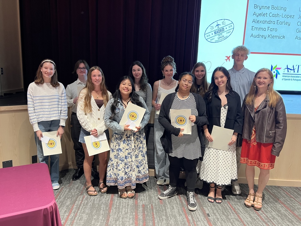 A group of students standing together with certificates of accomplishment.