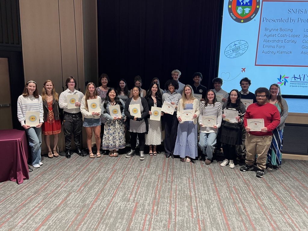 A group of students standing together with certificates of accomplishment.