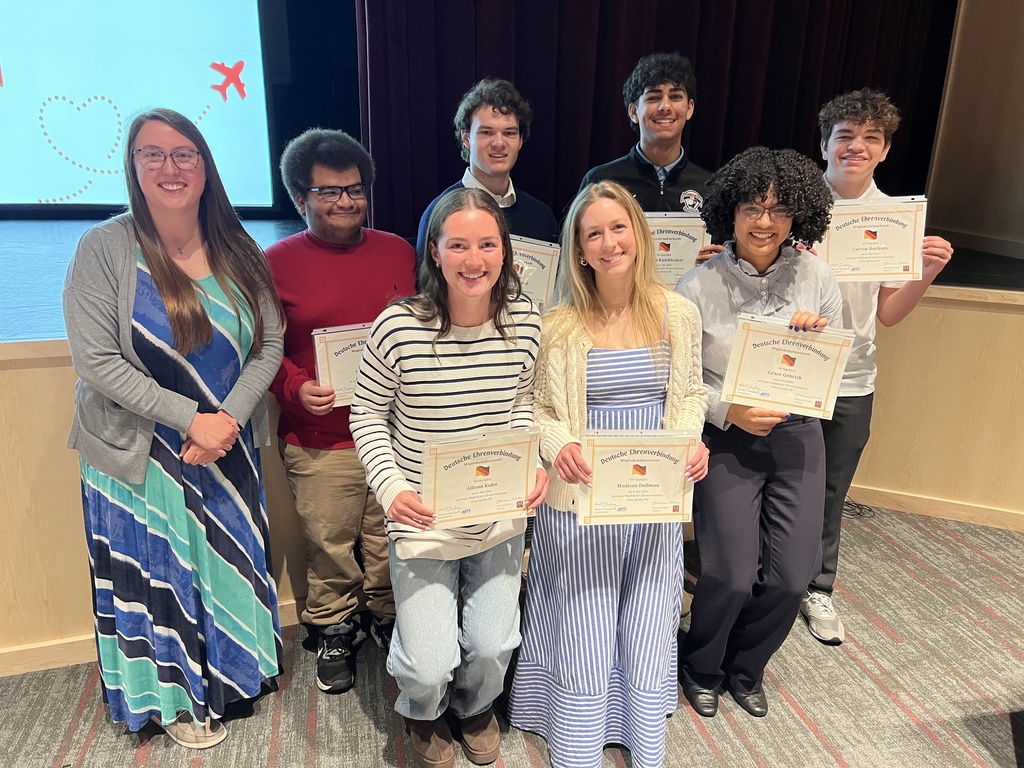 A group of students standing together with certificates of accomplishment.