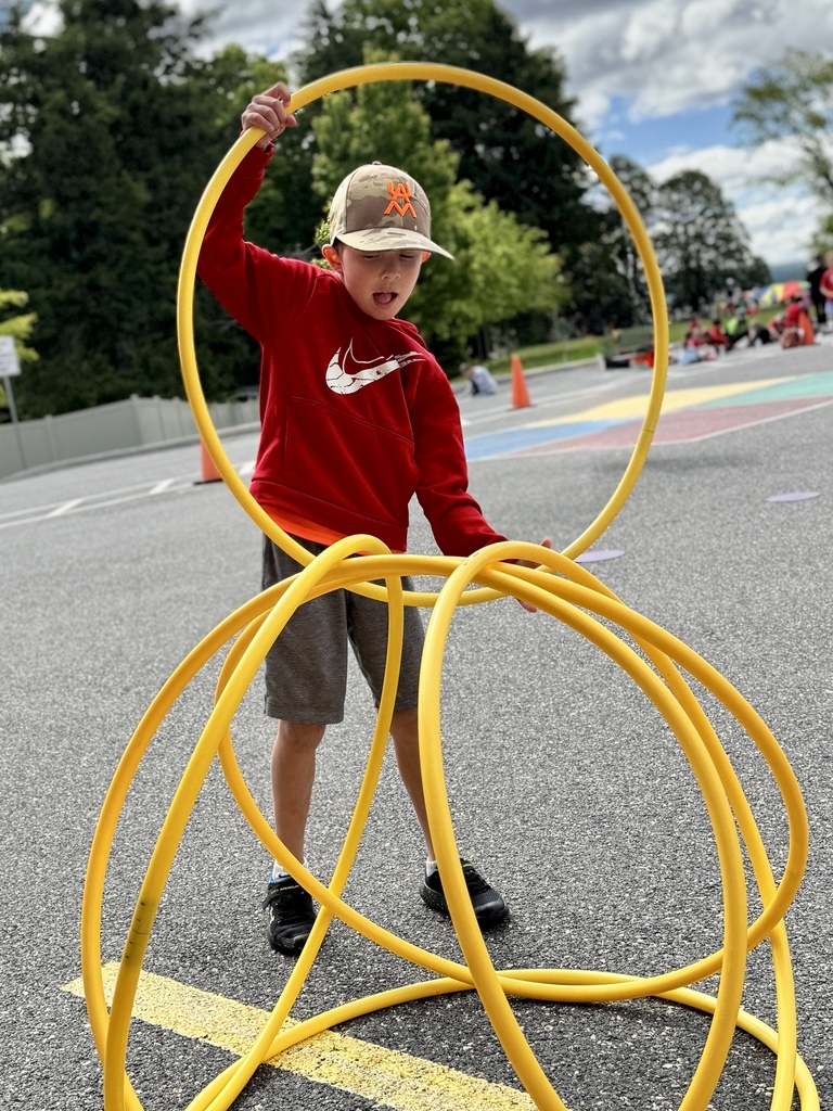 A young student work to pile hoops into a pyramid.