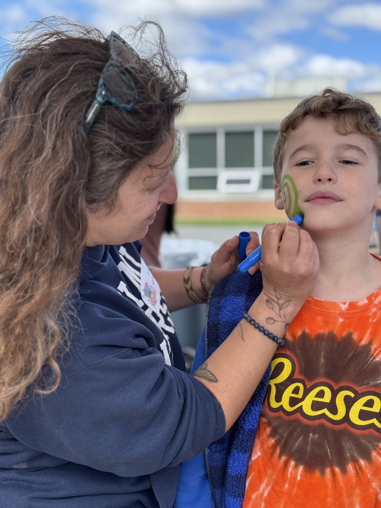 A student gets his face painted by a volunteer.