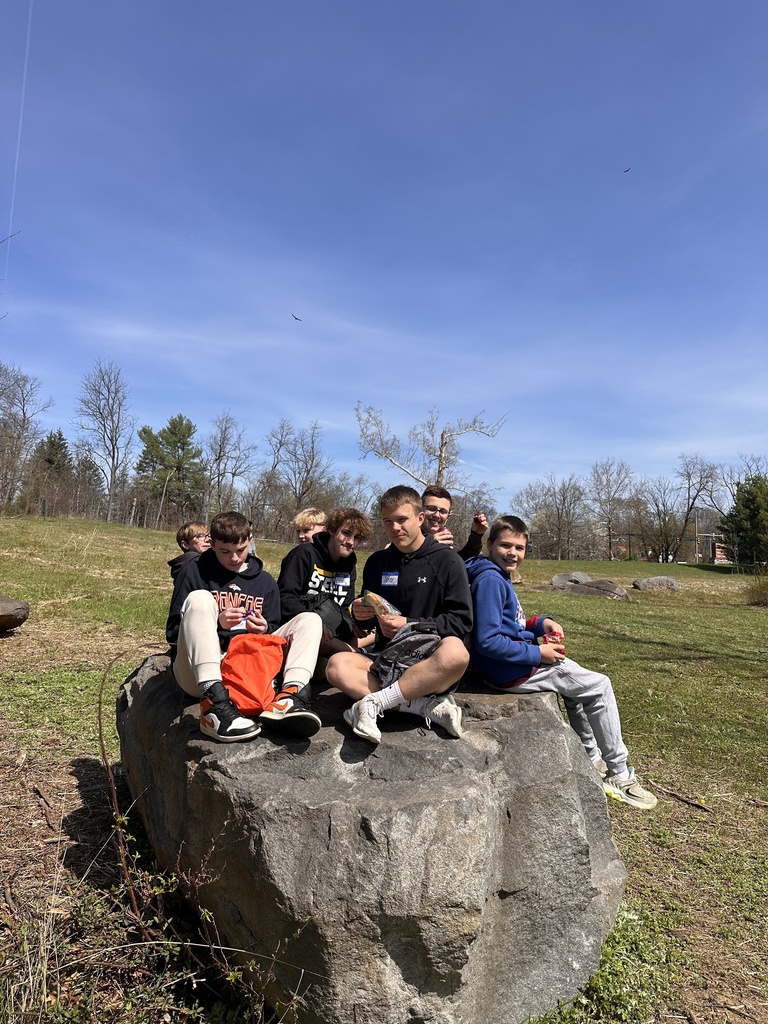 Students sit on a rock at Gettysburg National Military Park.