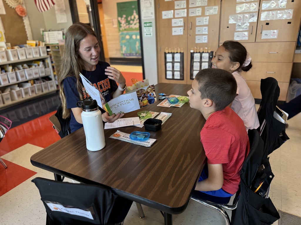 A high school student reads to elementary students.