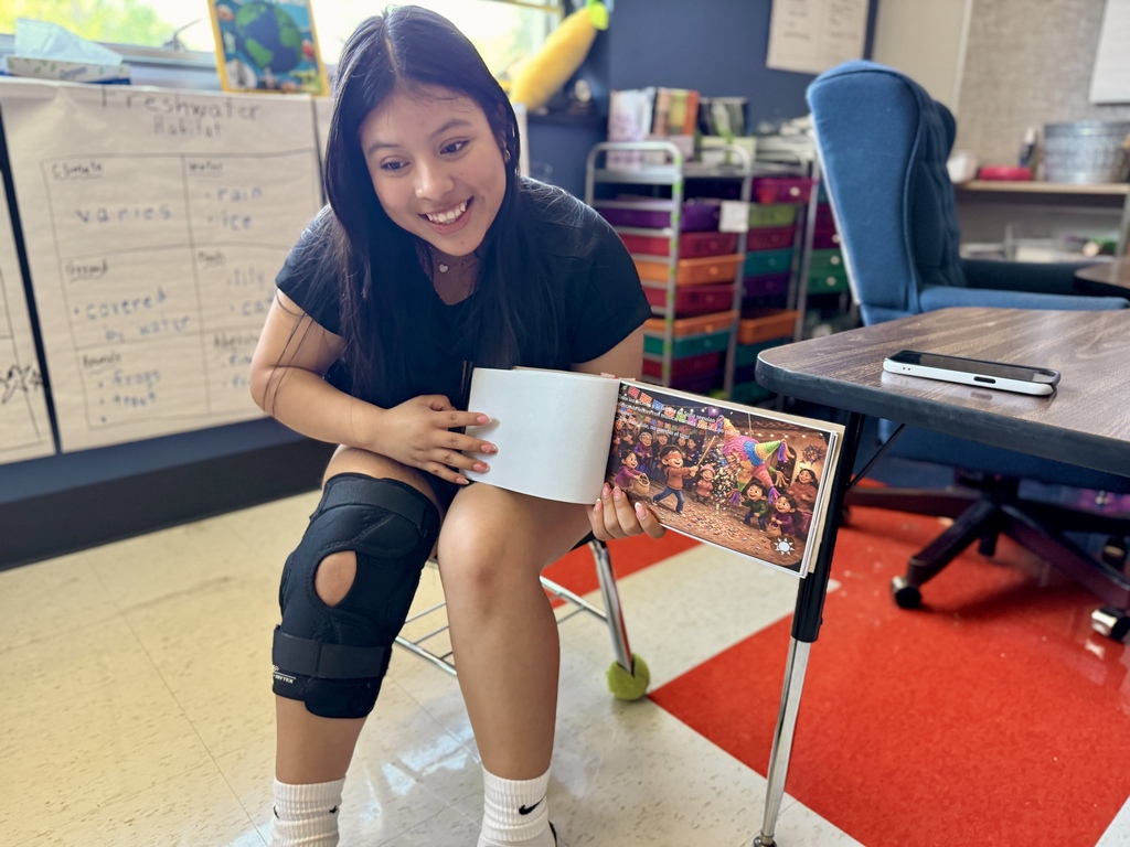 A high school student reads to elementary students.