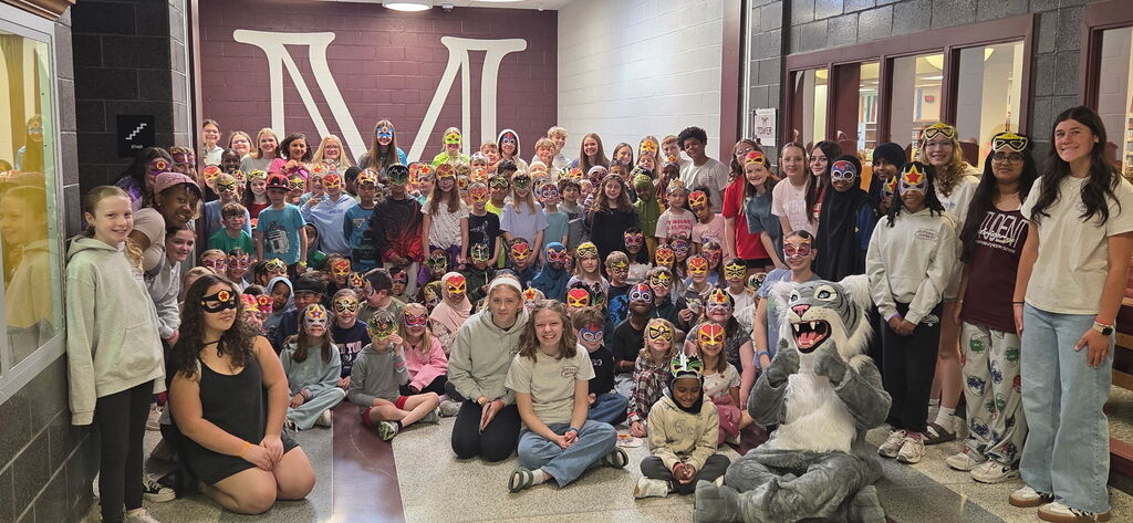 A large group of students wearing masks and posing for a photo.