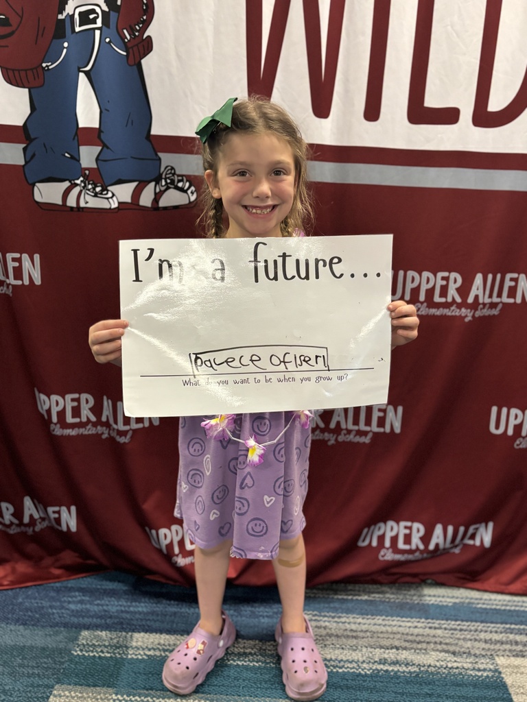 Young student wearing a cap and gown and holding a sign that says I'm a future police officer.