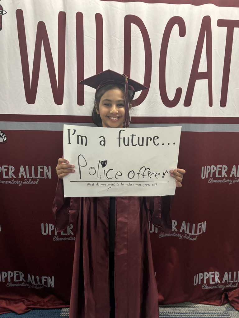 Young student wearing a cap and gown and holding a sign that says I'm a future Police officer.