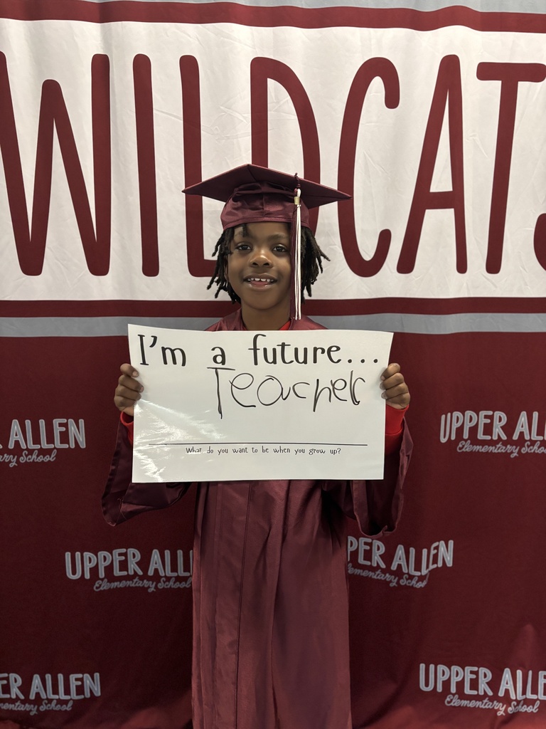 Young student wearing a cap and gown and holding a sign that says I'm a future teacher.