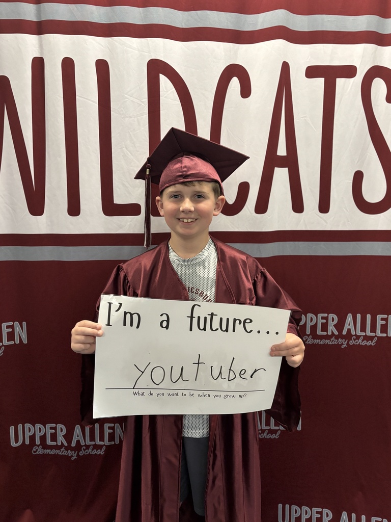 Young student wearing a cap and gown and holding a sign that says I'm a future you tuber.