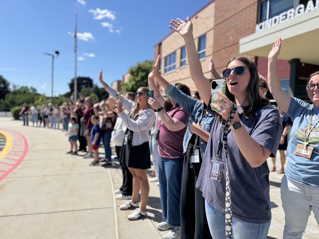 Teachers cheer and wave goodbye on the last day of school.