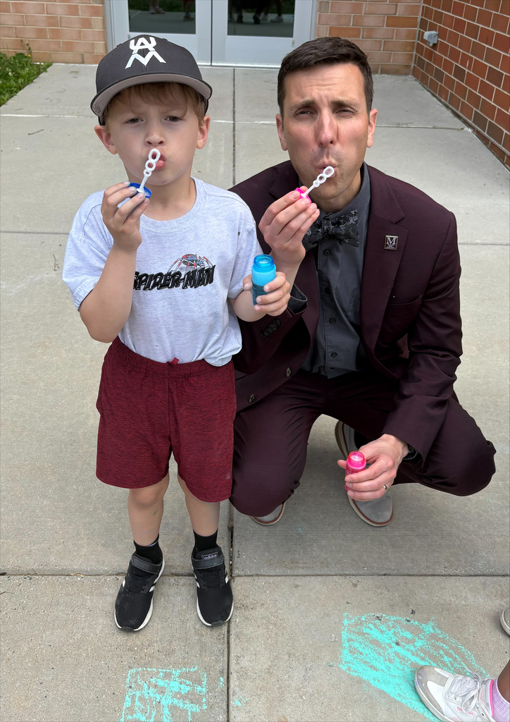 A young boy and a man blow bubbles.
