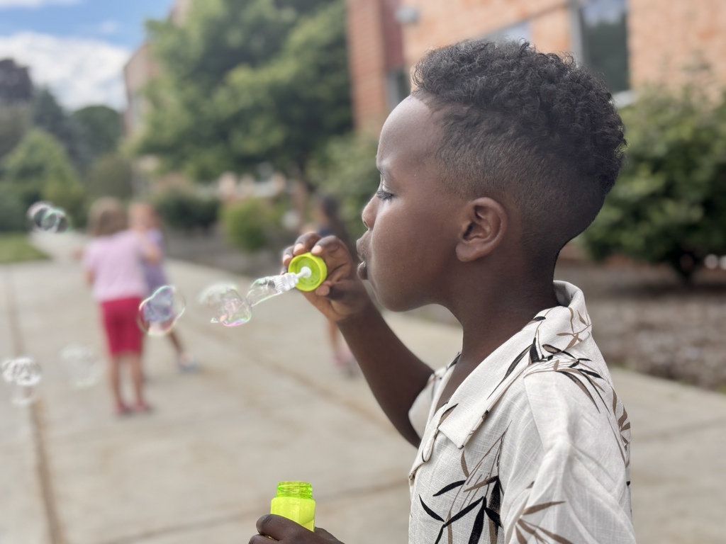 A young boy blows bubbles.