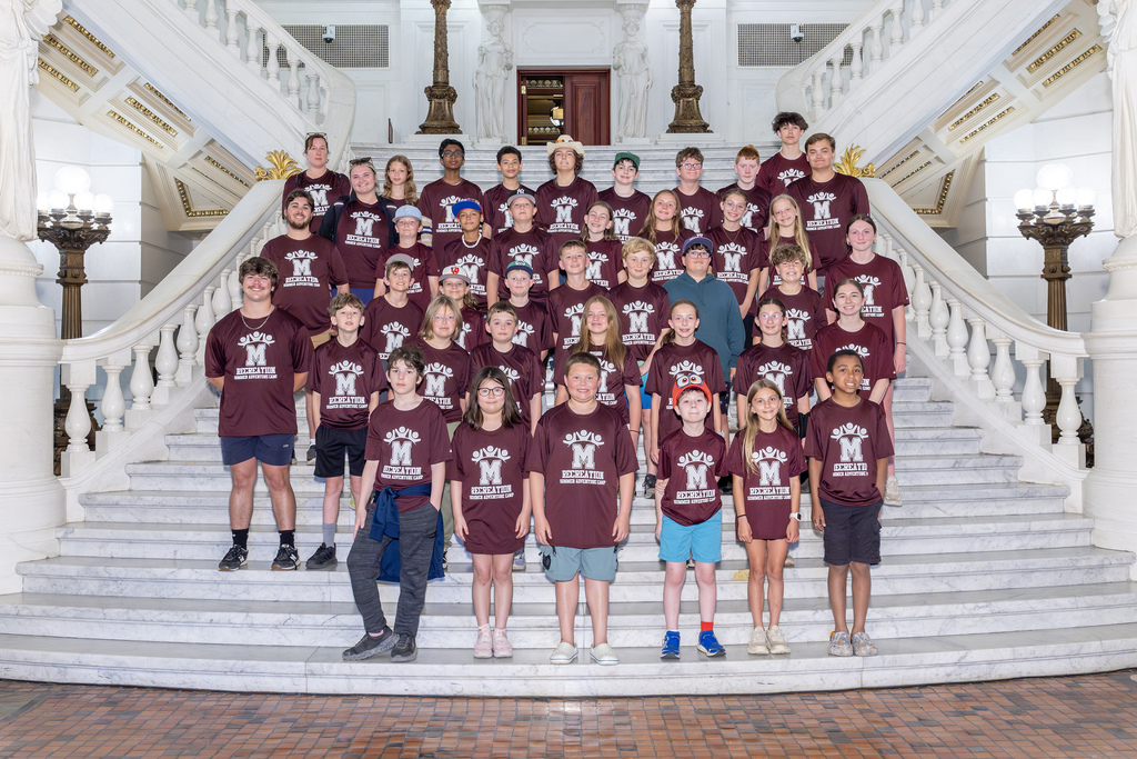 A group of students standing on the steps of the state Capitol.