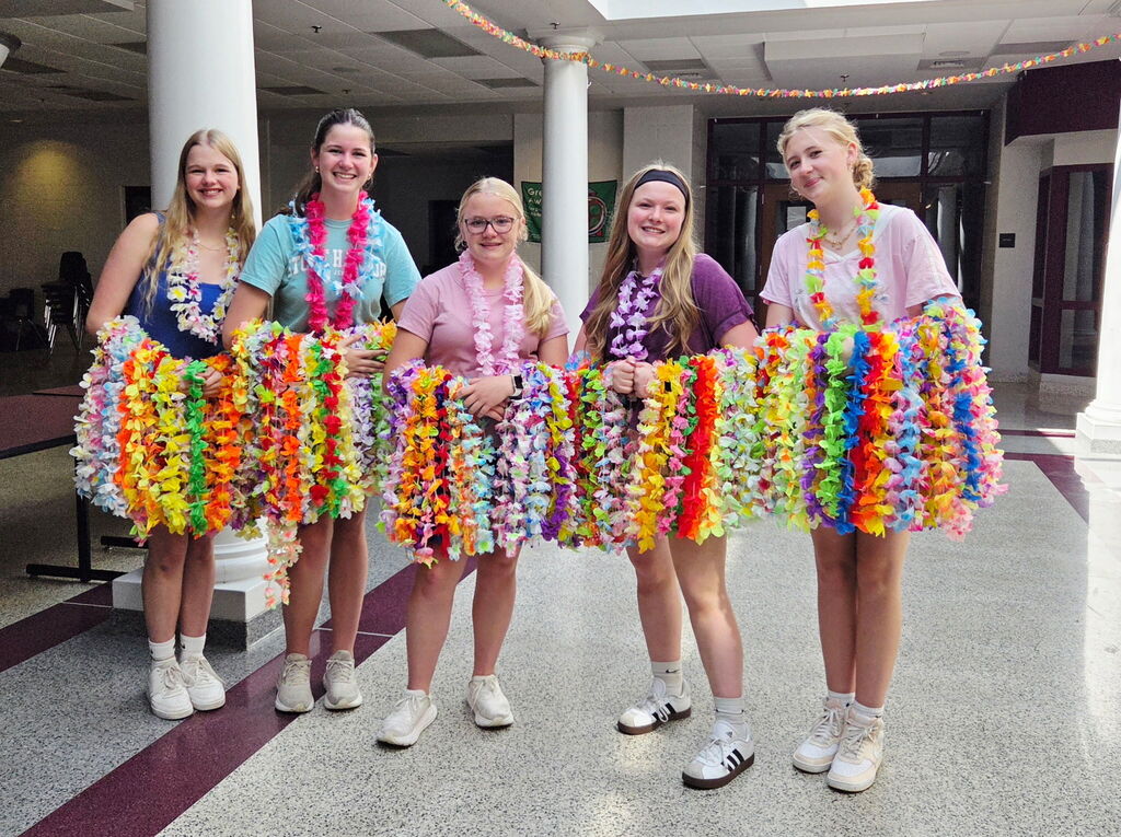 Students in a line holding a bunch of leis.