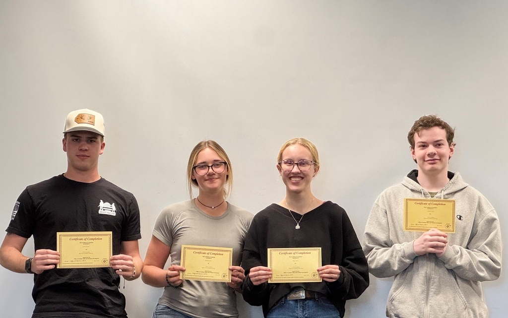 A group of students standing in a line and holding certificates of completion.