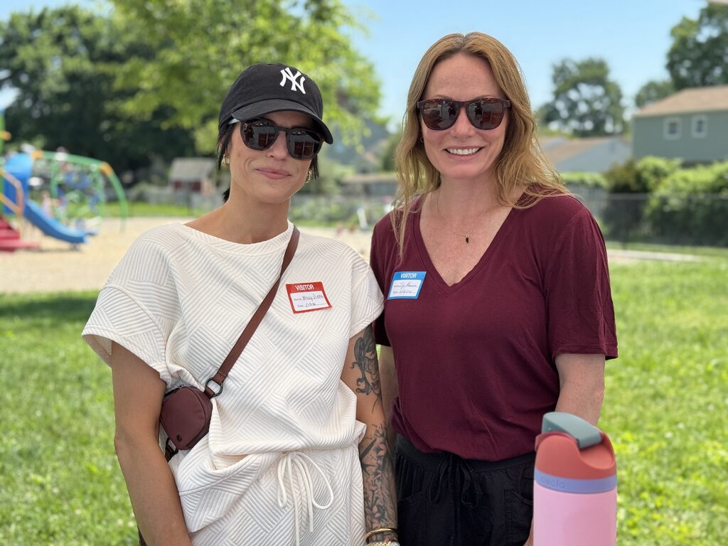 Two volunteers standing side by side at a school event.