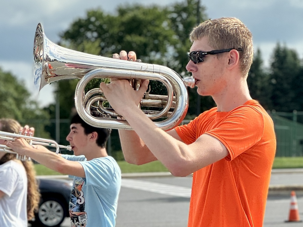 Students hold instruments and practice marching.