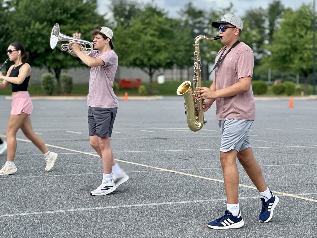 Students hold instruments and practice marching.