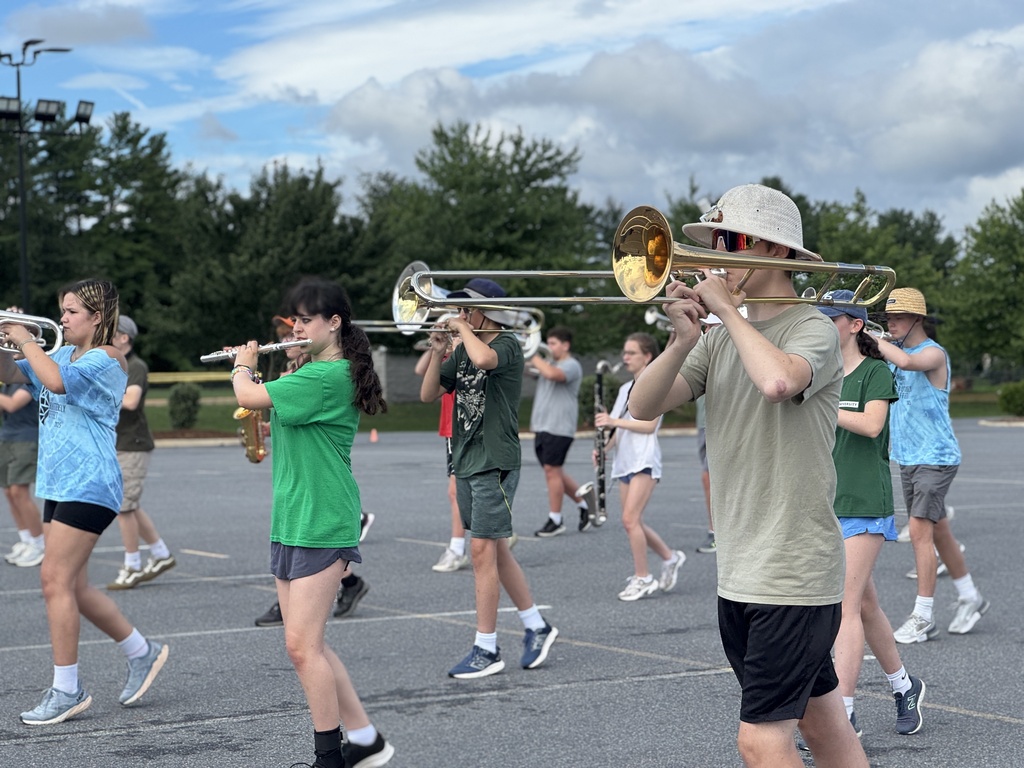 Students hold instruments and practice marching.