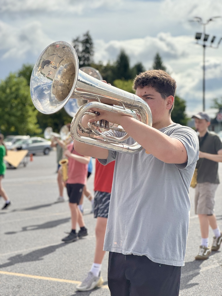 Students hold instruments and practice marching.