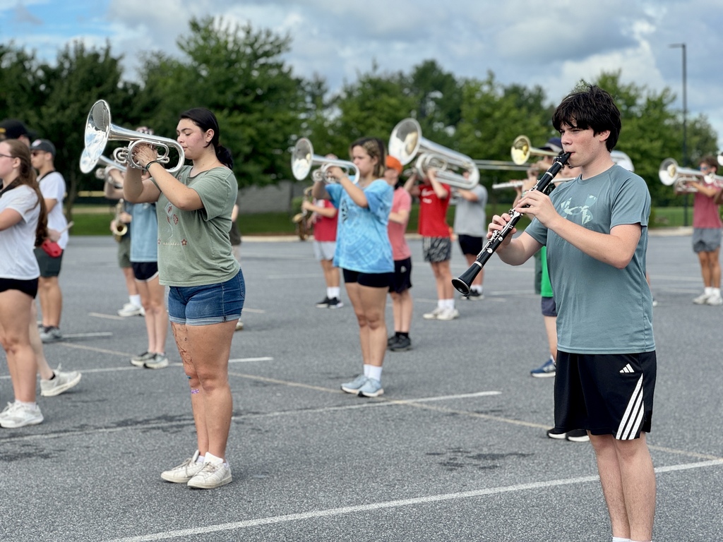 Students hold instruments and practice marching.