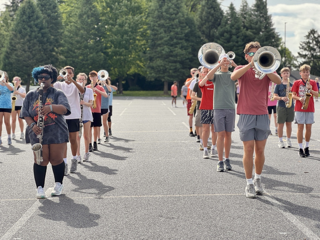 Students hold instruments and practice marching.