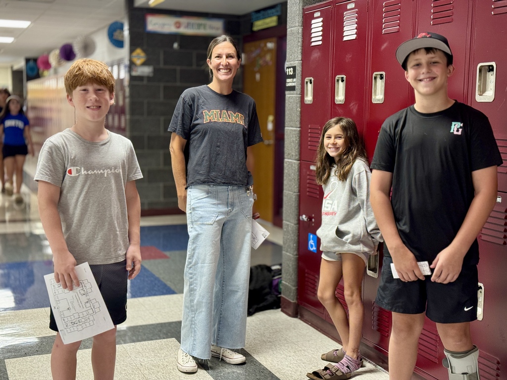 A family stands beside lockers in a school hallway.