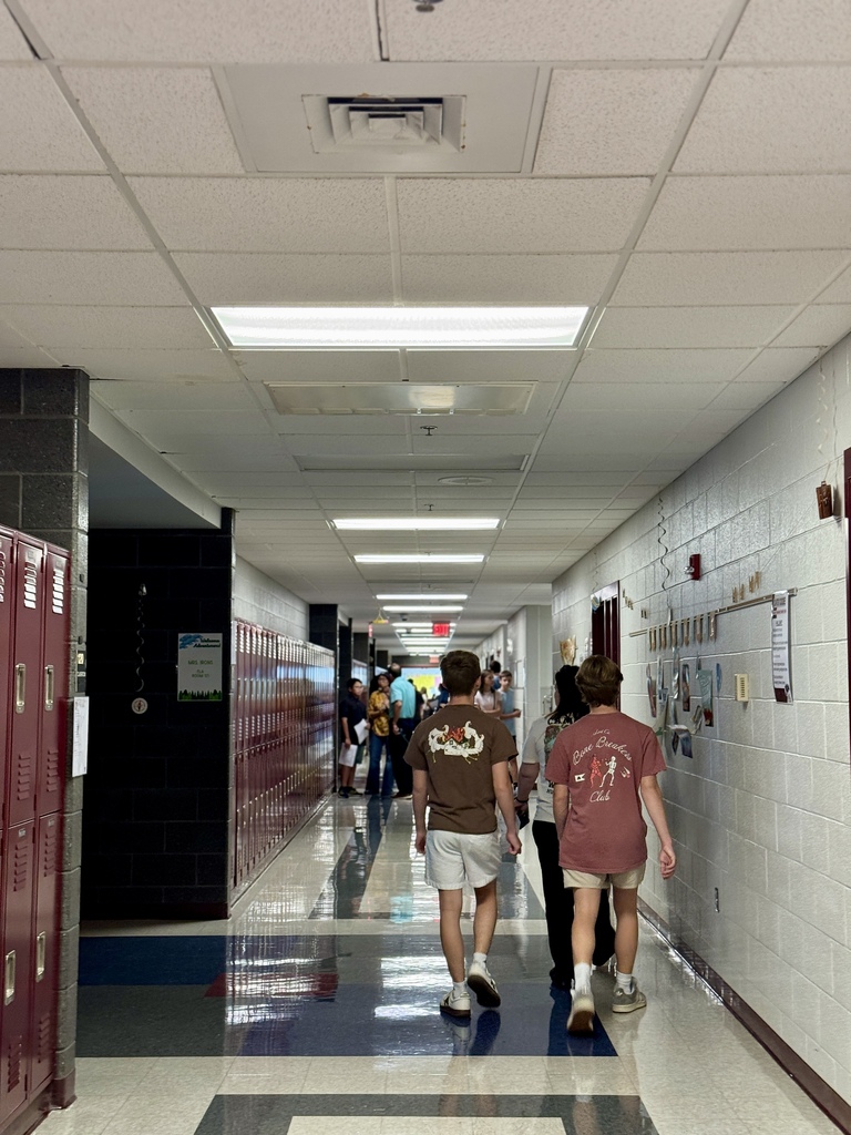 Students and families walk down a school hallway.