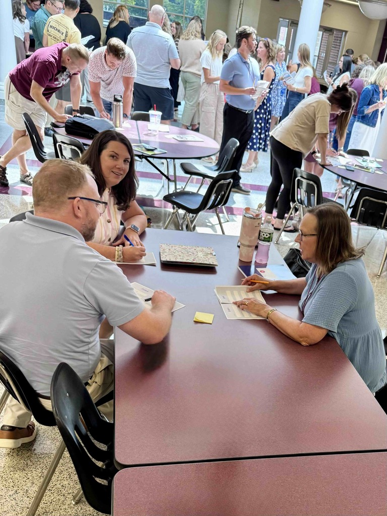 A group of teachers gathered around tables for professional development