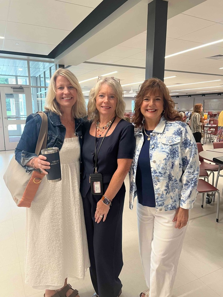 Three ladies standing beside each other and posing for a photo.