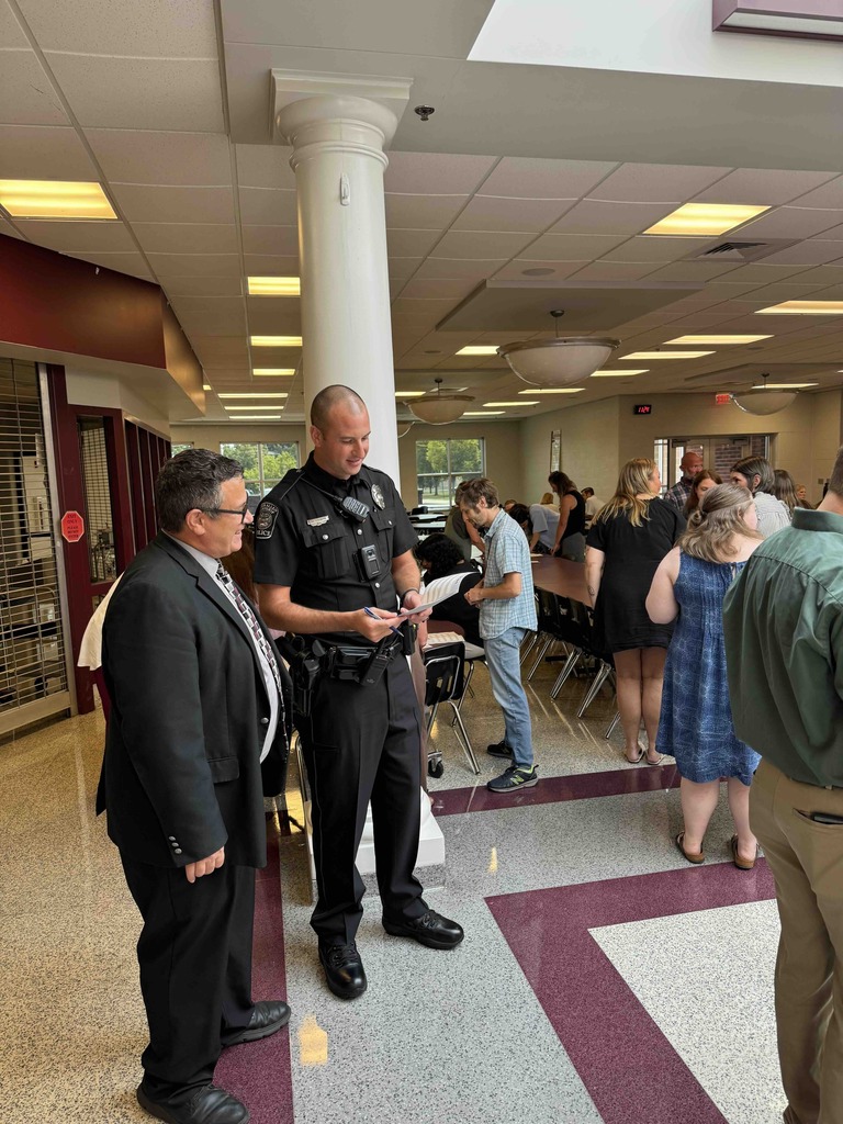 A group of teachers standing in a school cafeteria for professional development.