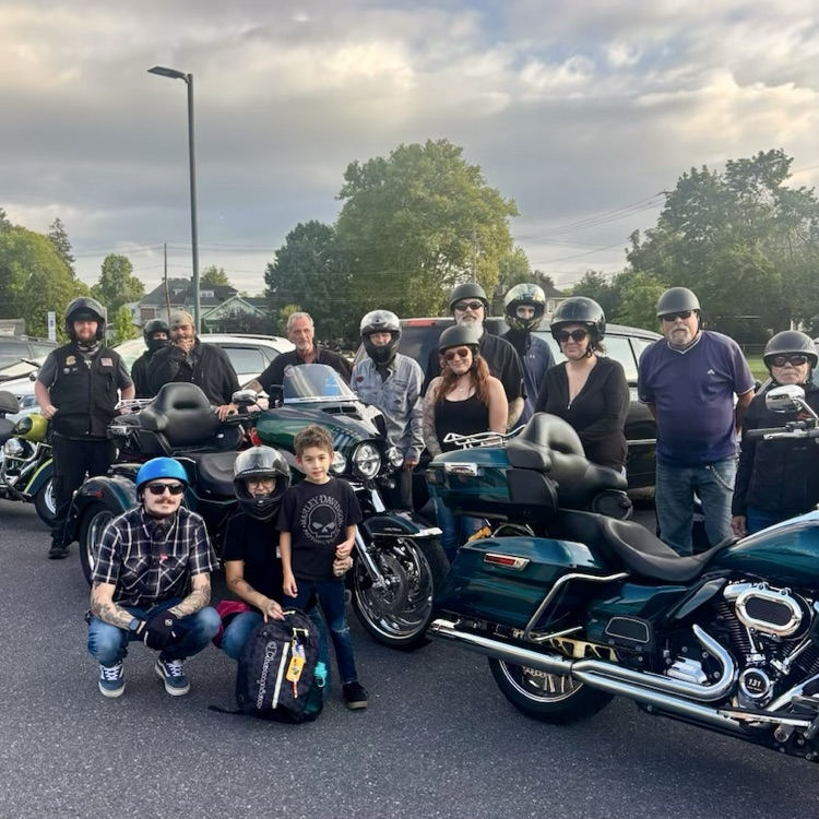 a young boy with a group of motorcycle drivers
