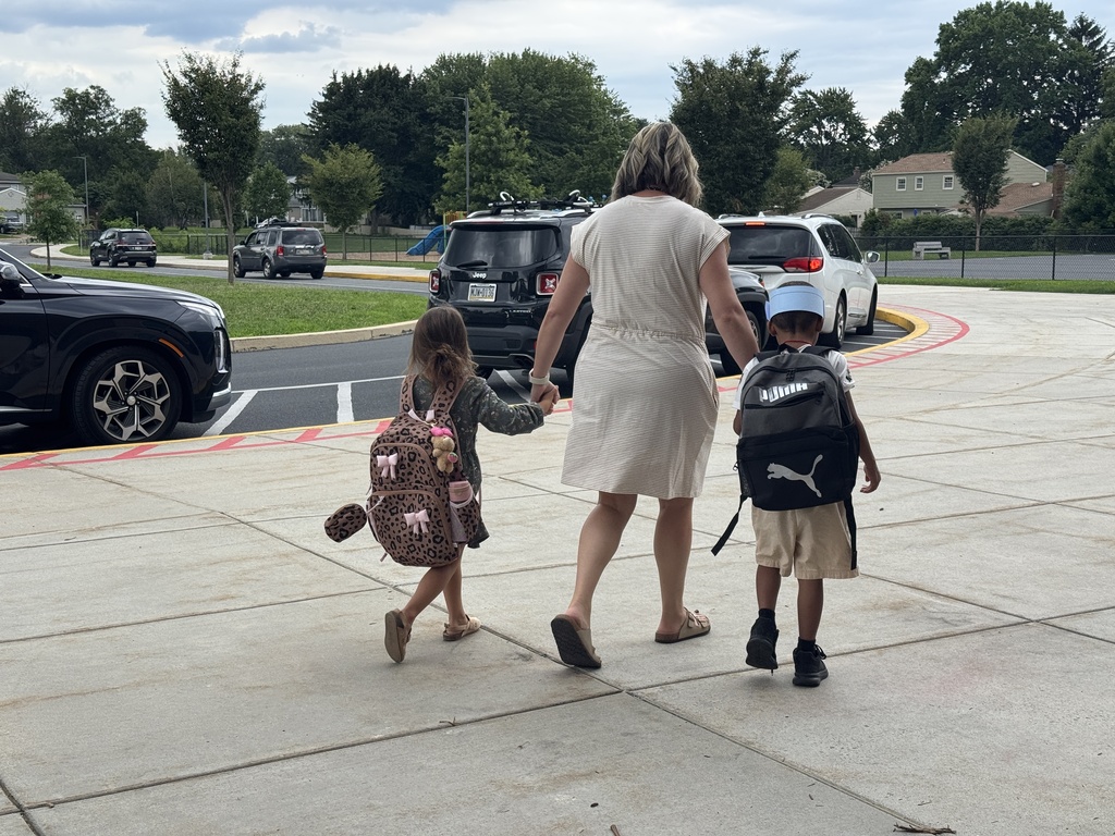 Students walking out of a school with a teacher.