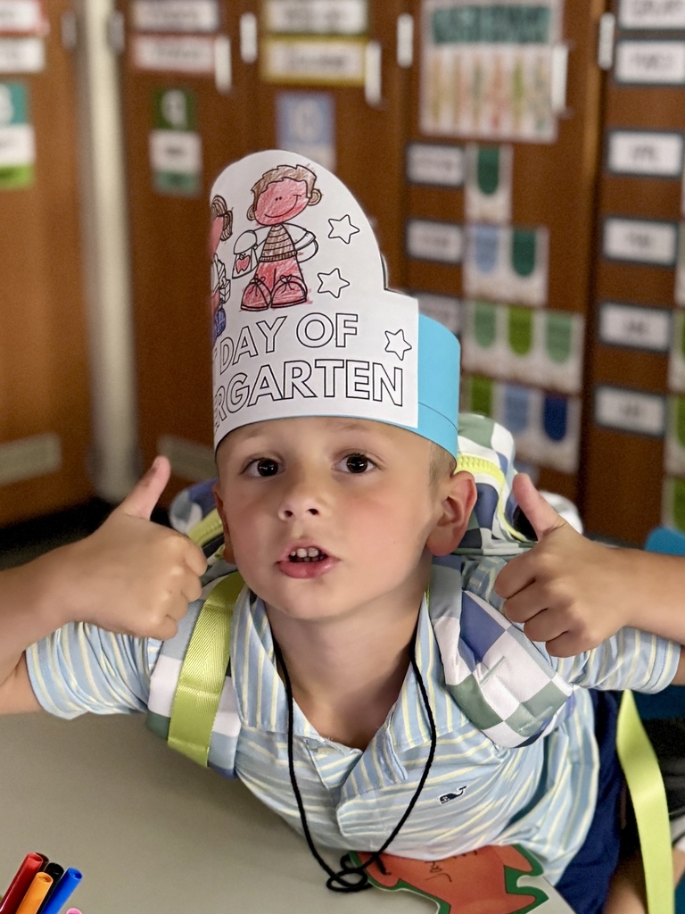 A little boy gives two thumbs up.