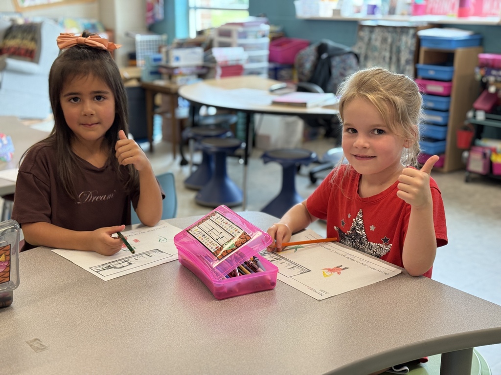 Little girls smile and give thumbs up.