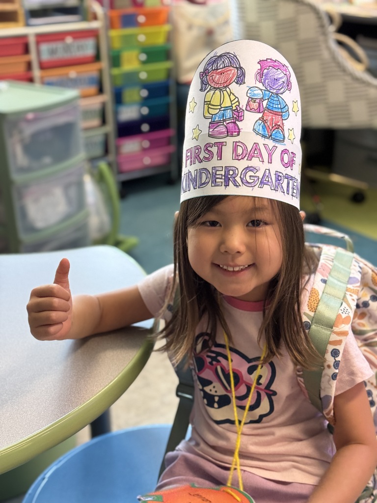 A little girl gives a thumbs up.