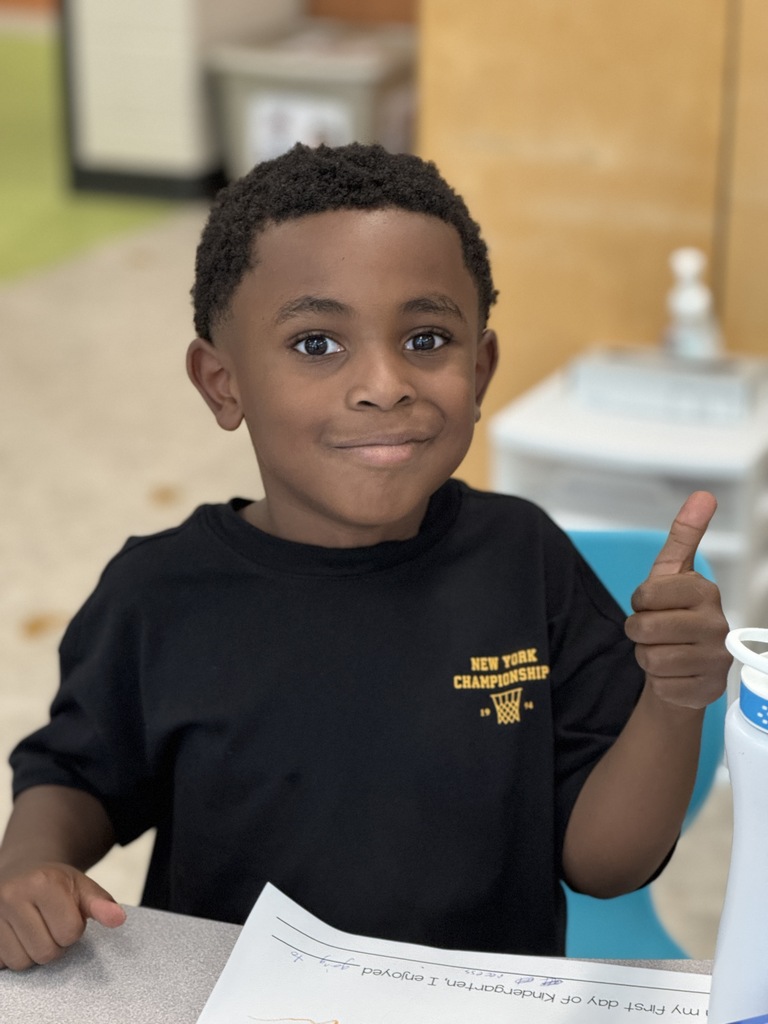 A little boy gives a thumbs up.