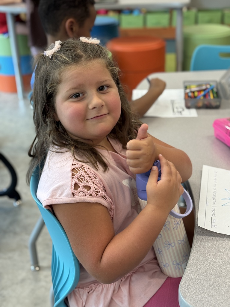A little girls gives a thumbs up.