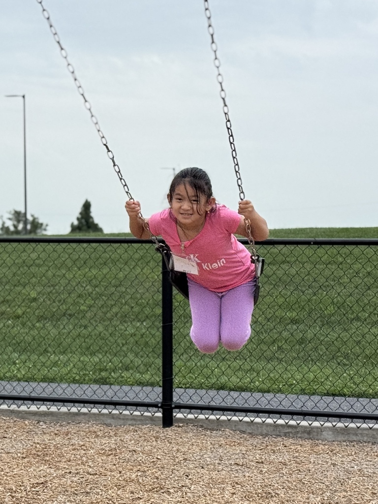 A girl on the swings of a school playground