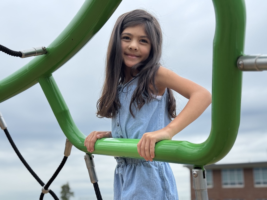 A little girl plays on a school playground.