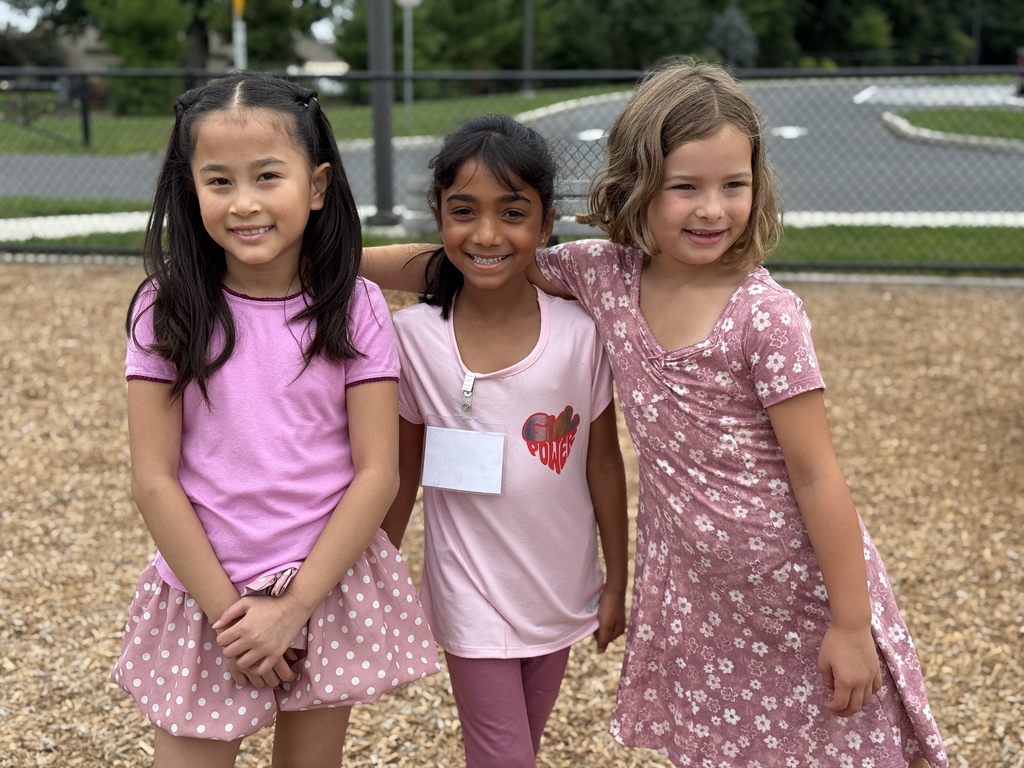 Three young girls on a school playground.