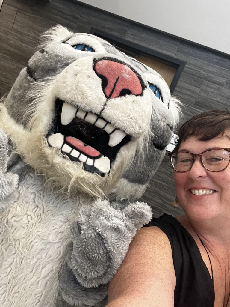 Wildcat mascot taking a selfie with a staff member.
