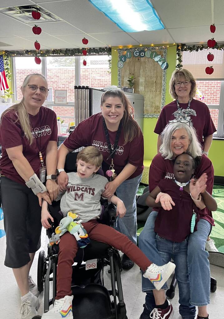 A group of students and staff proudly wearing maroon and steel colored shirts.