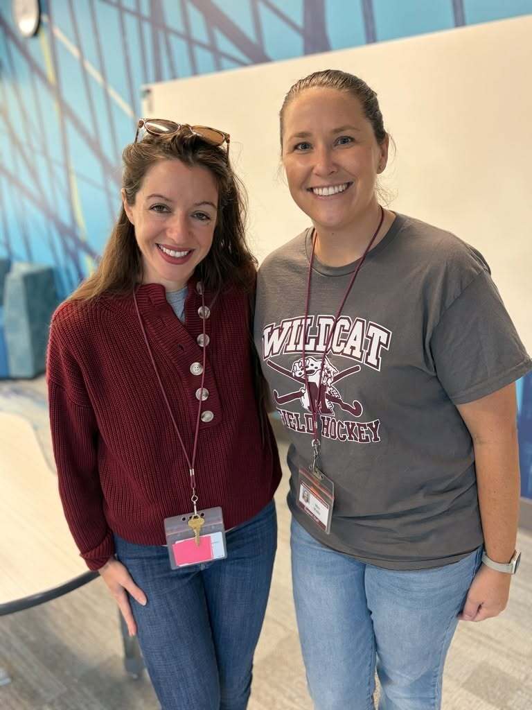 Two ladies proudly wear their maroon and steel colored shirts.