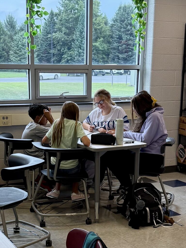 Students work together on math problems in a middle school classroom.
