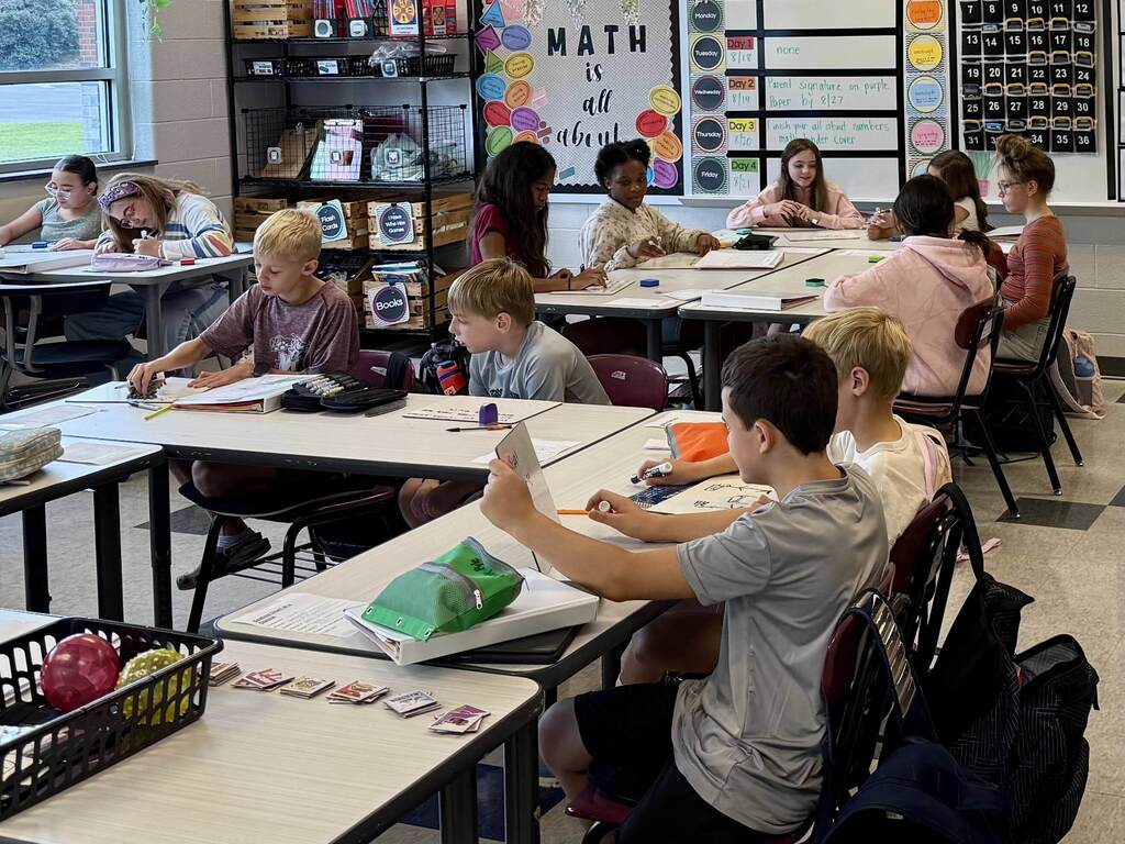 Students work together on math problems in a middle school classroom.