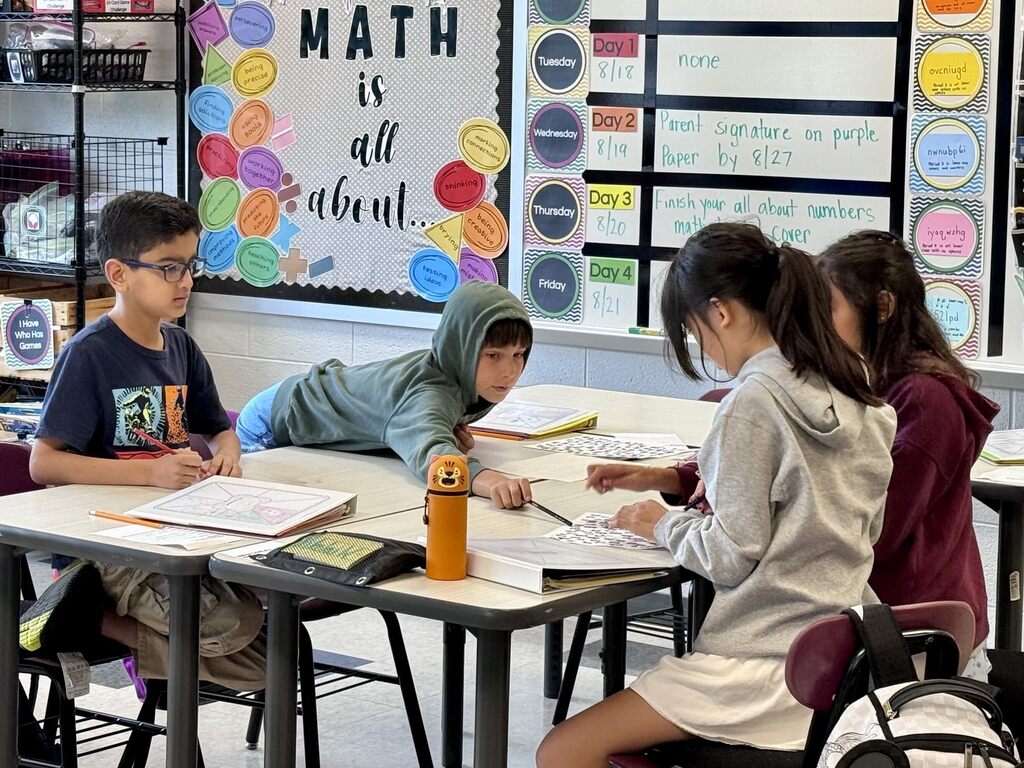 Students work together on math problems in a middle school classroom.