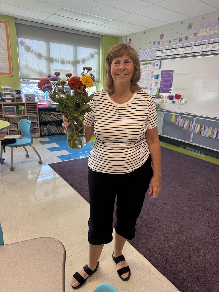 A staff member holds a bouquet of flowers she put together.