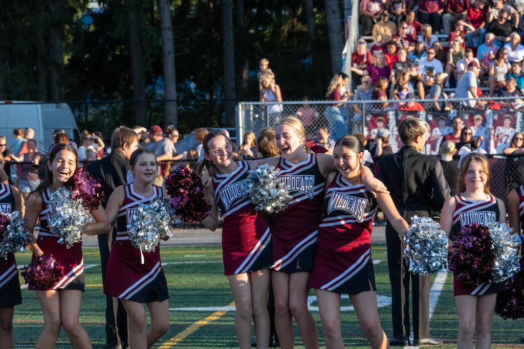 Cheerleaders stand arm in arm